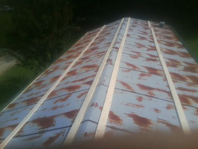 Rusted metal roof panels with new wood purlins before replacement — Storm Damage Roof Repair in Johnson City by Roofing Brothers