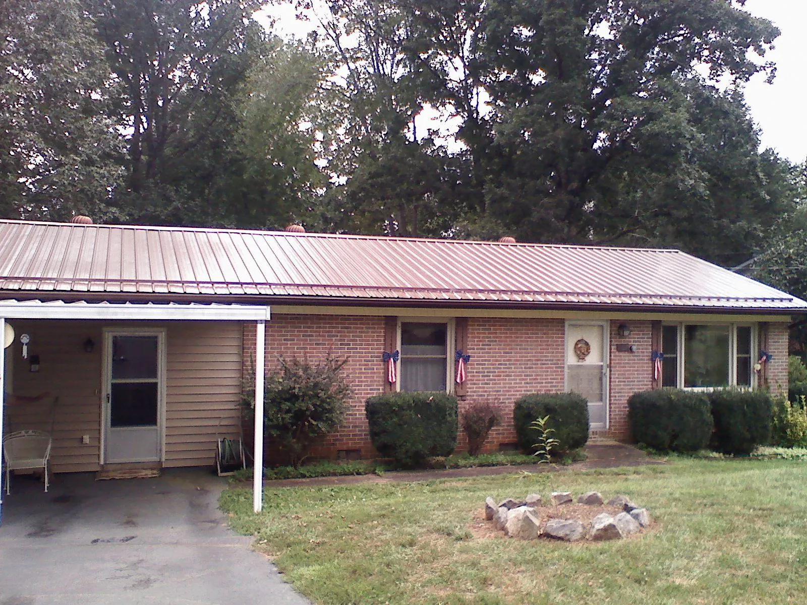 Bronze metal roof and carport on a brick ranch home — Roof Repair work by our crew in Johnson City